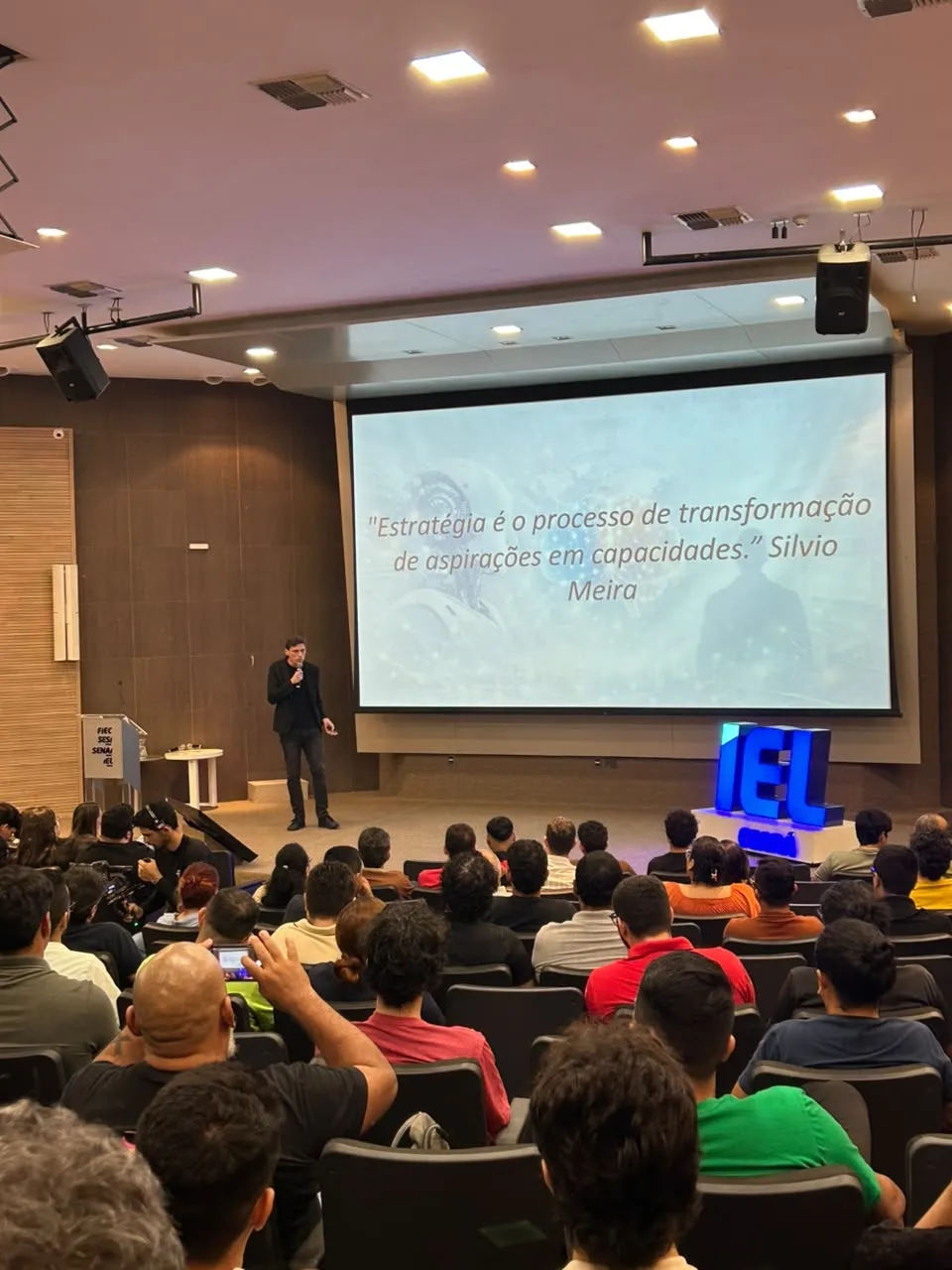 Daniel Monteiro palestrando em auditório lotado